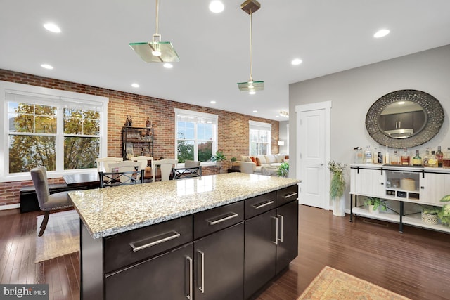 kitchen featuring hanging light fixtures, a wealth of natural light, and brick wall