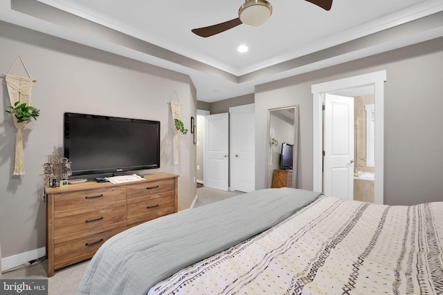 bedroom featuring ensuite bath, ceiling fan, and a raised ceiling