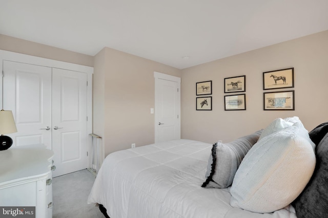 bedroom with light carpet and a closet