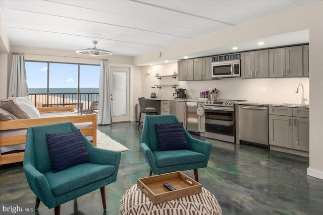 living room featuring a water view and sink