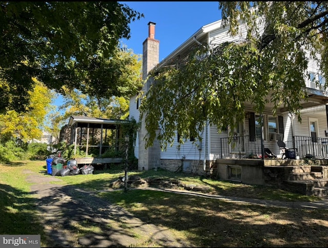 view of side of property featuring a sunroom and a porch