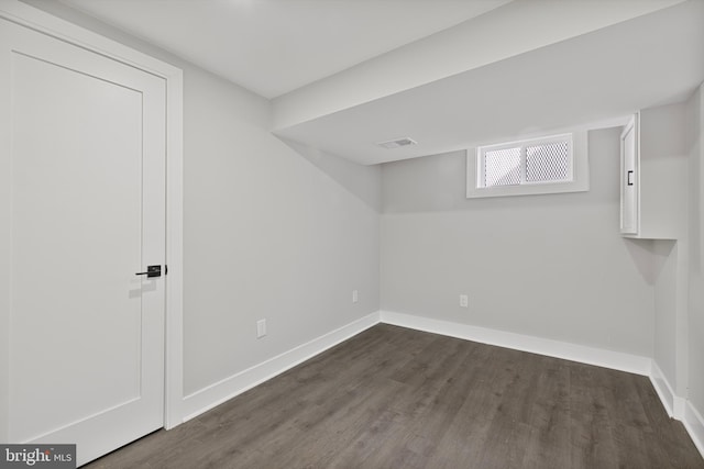 basement with dark hardwood / wood-style flooring