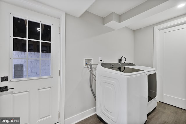 clothes washing area featuring dark wood-type flooring and separate washer and dryer