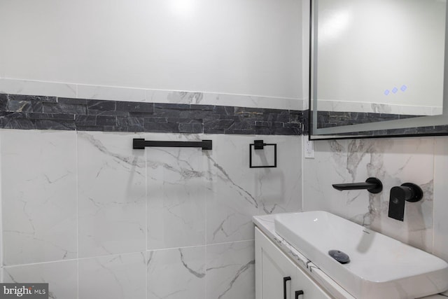 bathroom featuring a sink and tile walls