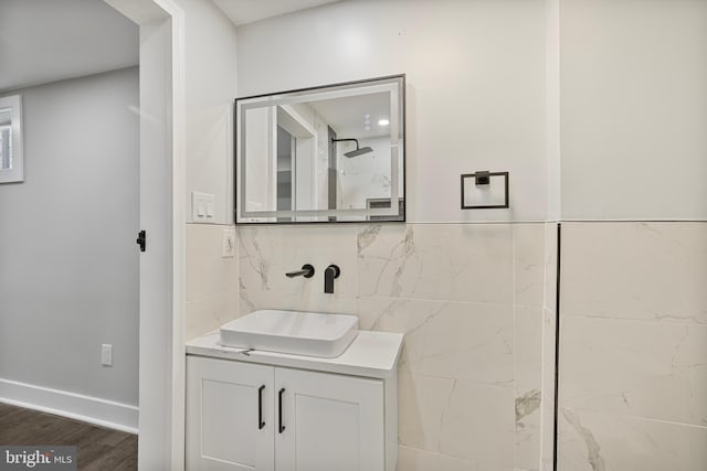 bathroom with tile walls, vanity, wood-type flooring, and walk in shower