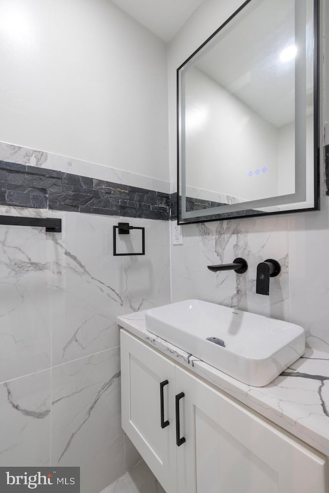 bathroom with vanity and tile walls