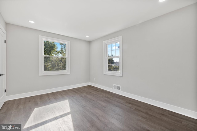 spare room featuring dark wood-type flooring, baseboards, and recessed lighting