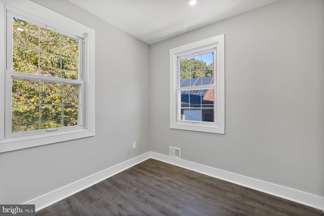 spare room featuring baseboards, dark wood finished floors, and recessed lighting