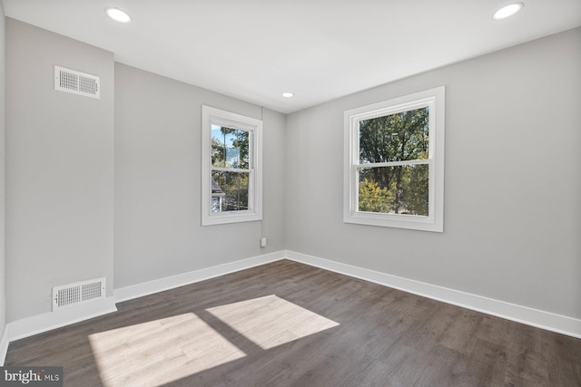 spare room with dark wood-style floors, baseboards, and recessed lighting