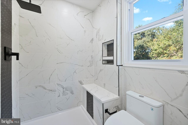 bathroom featuring toilet and a tile shower