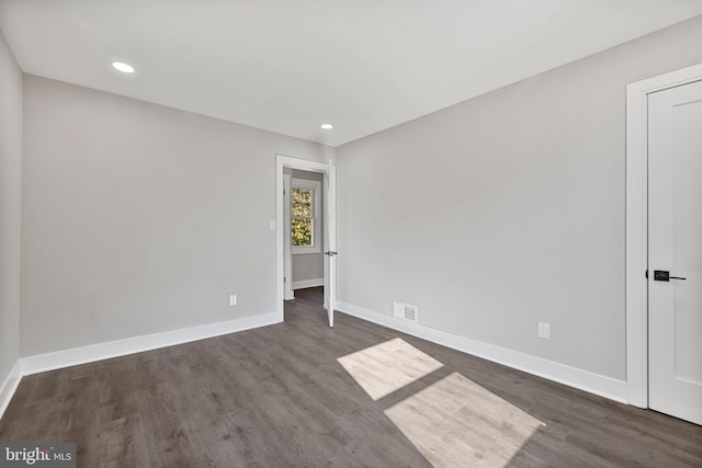 empty room with dark hardwood / wood-style flooring