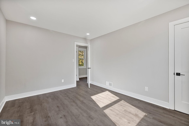 spare room featuring wood finished floors, baseboards, and recessed lighting
