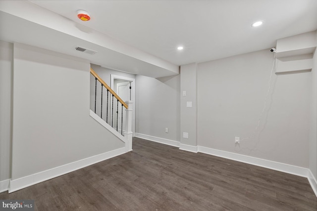 finished below grade area with dark wood-style flooring, baseboards, recessed lighting, and stairway
