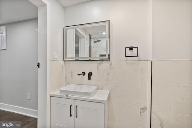 bathroom featuring vanity, wood finished floors, and baseboards