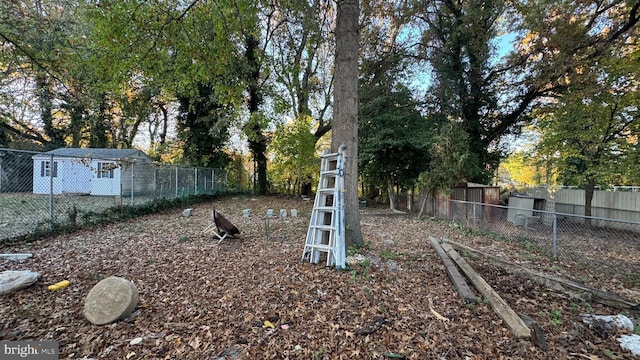 view of yard featuring fence and view of wooded area