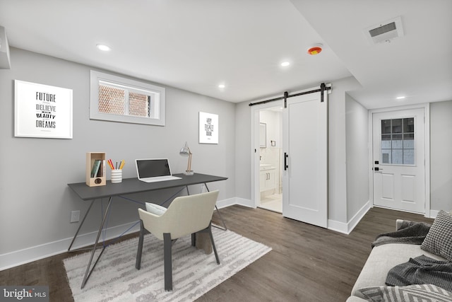 office area featuring dark wood-type flooring and a barn door