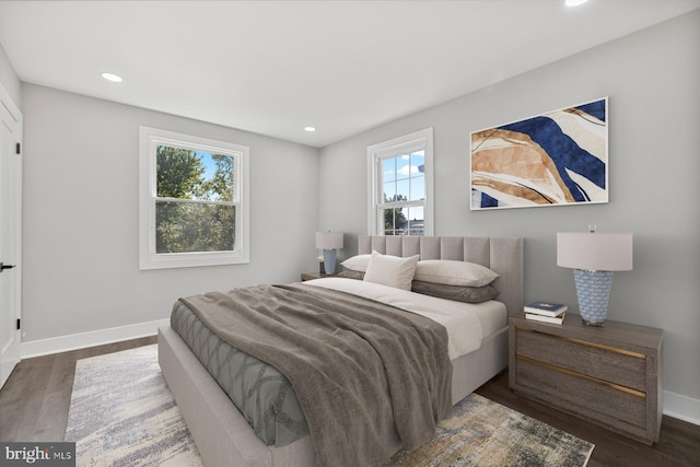 bedroom featuring baseboards, wood finished floors, and recessed lighting
