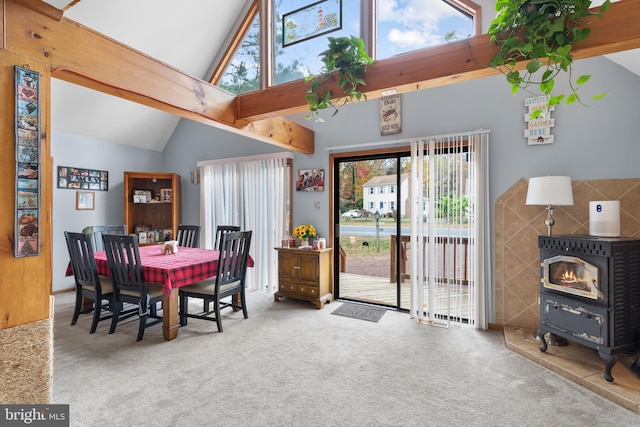 dining space featuring a wood stove, beamed ceiling, carpet floors, and high vaulted ceiling