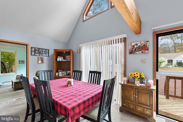 carpeted dining room with high vaulted ceiling