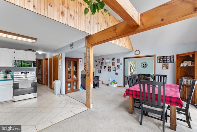 tiled dining room featuring beamed ceiling and high vaulted ceiling