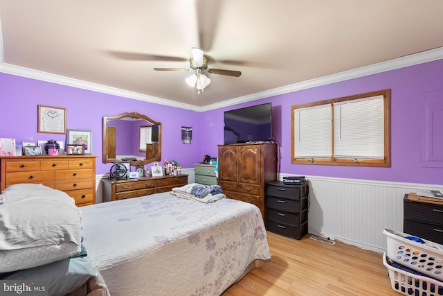 bedroom with ceiling fan, crown molding, and light hardwood / wood-style flooring