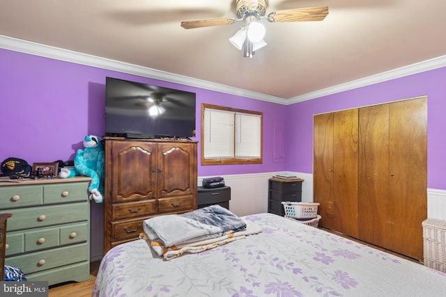 bedroom with ceiling fan, light hardwood / wood-style floors, crown molding, and a closet