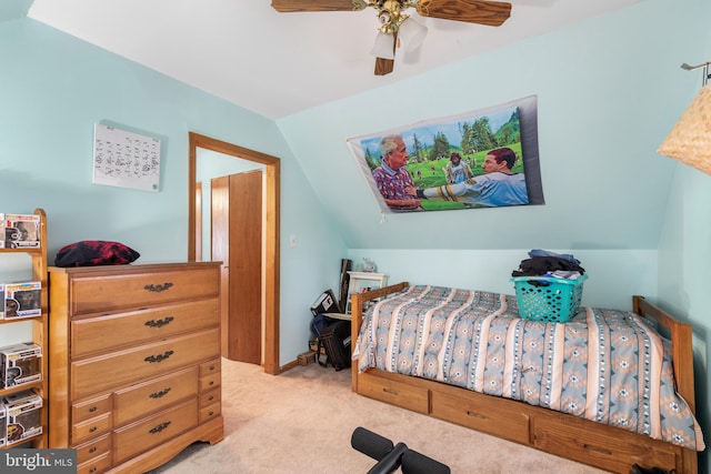 carpeted bedroom with ceiling fan and vaulted ceiling