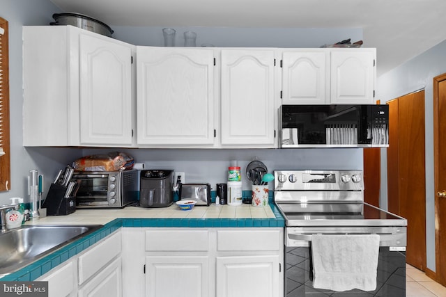 kitchen featuring stainless steel range with electric stovetop, sink, tile countertops, white cabinets, and light tile patterned flooring