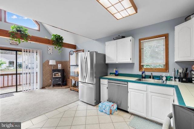 kitchen featuring appliances with stainless steel finishes, white cabinetry, a healthy amount of sunlight, and sink