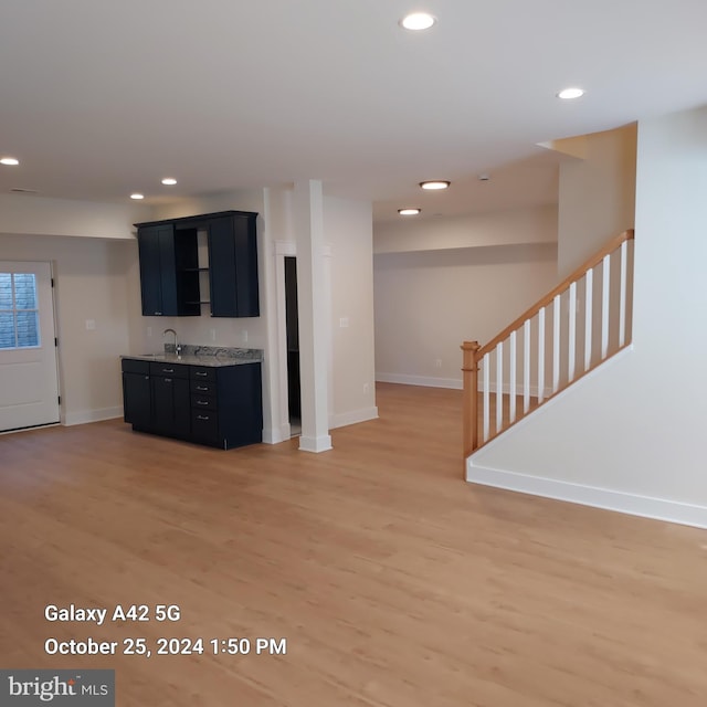 unfurnished living room featuring sink and hardwood / wood-style floors