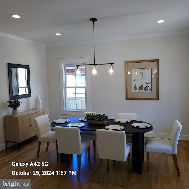 dining space with ornamental molding and dark wood-type flooring