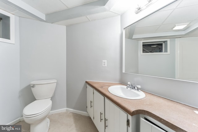 bathroom featuring vanity, a drop ceiling, toilet, and tile patterned flooring