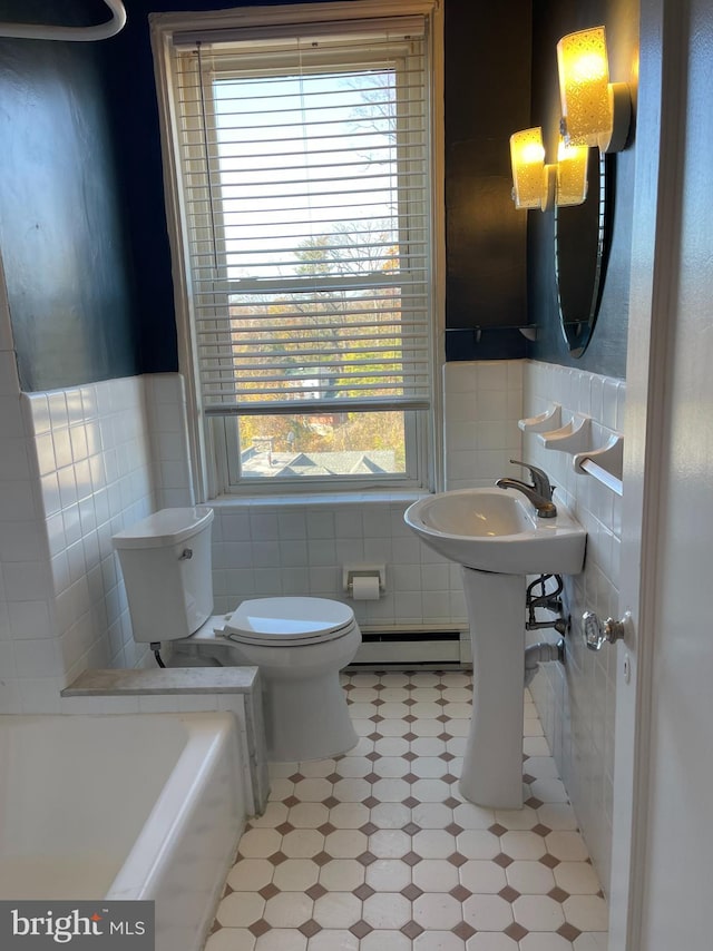 bathroom featuring a tub to relax in, toilet, tile walls, and a baseboard heating unit