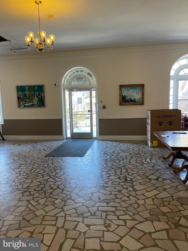 foyer featuring a notable chandelier and crown molding