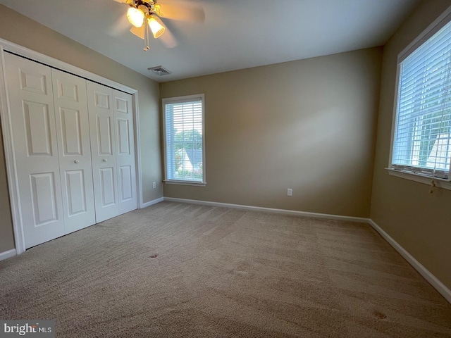 unfurnished bedroom with a closet, ceiling fan, and carpet