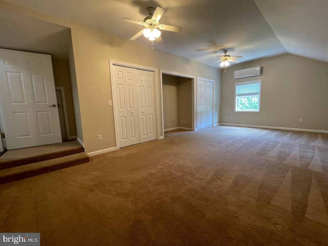 unfurnished bedroom with lofted ceiling, carpet floors, multiple closets, and an AC wall unit