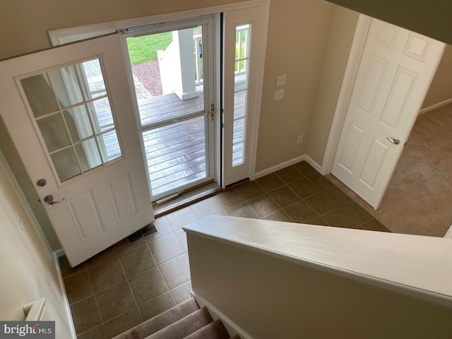 entryway featuring dark tile patterned floors