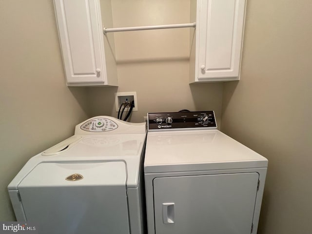 laundry room with cabinets and washer and clothes dryer