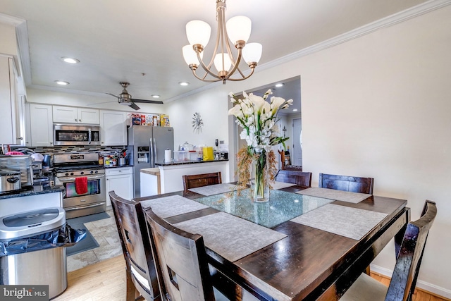 dining room with ornamental molding, ceiling fan with notable chandelier, and light hardwood / wood-style flooring