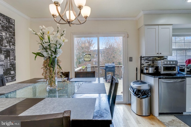 dining room featuring light wood-type flooring, an inviting chandelier, and ornamental molding