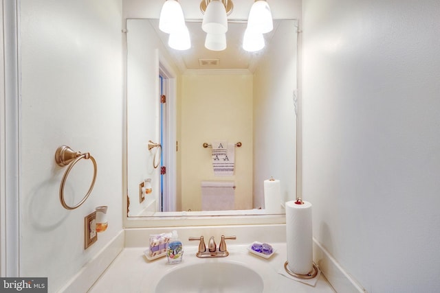 bathroom featuring an inviting chandelier, sink, and crown molding