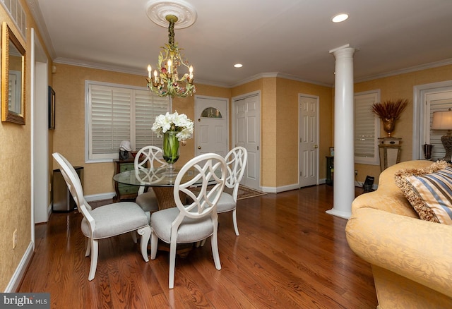 dining space with decorative columns, hardwood / wood-style flooring, crown molding, and a notable chandelier