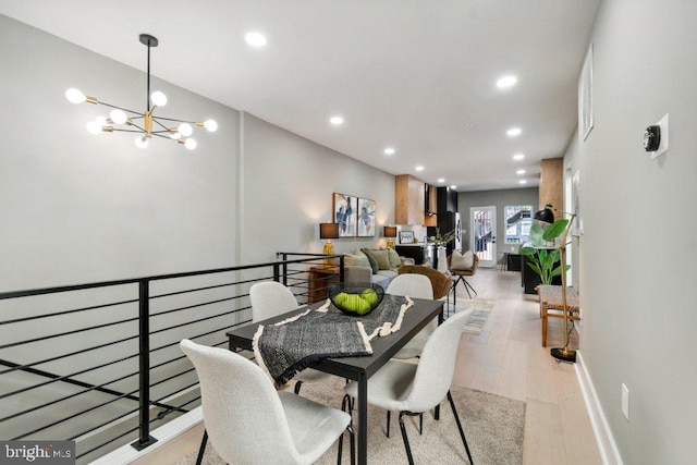 dining space featuring light hardwood / wood-style floors and an inviting chandelier