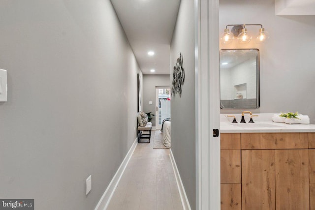 corridor featuring light hardwood / wood-style floors and sink