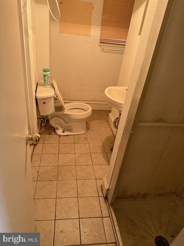 bathroom featuring walk in shower, toilet, and tile patterned flooring