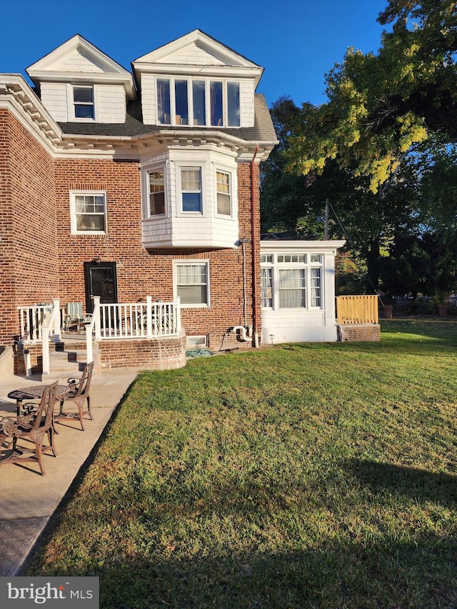 rear view of house with a yard and a patio