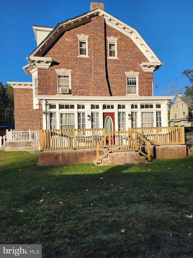 back of property with cooling unit, a deck, and a lawn