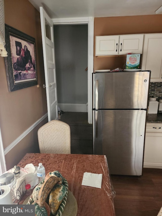 kitchen featuring white cabinetry, stainless steel fridge, backsplash, and dark hardwood / wood-style floors