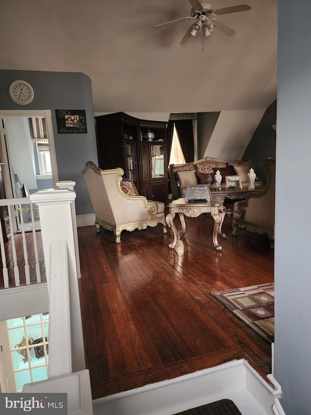 living room featuring dark wood-type flooring, vaulted ceiling, and ceiling fan