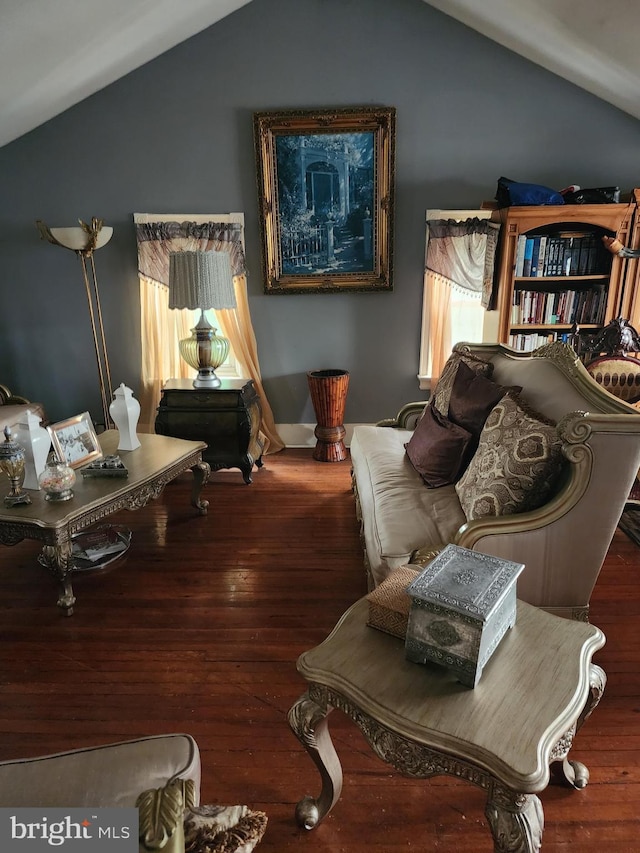 living room featuring dark wood-type flooring and vaulted ceiling